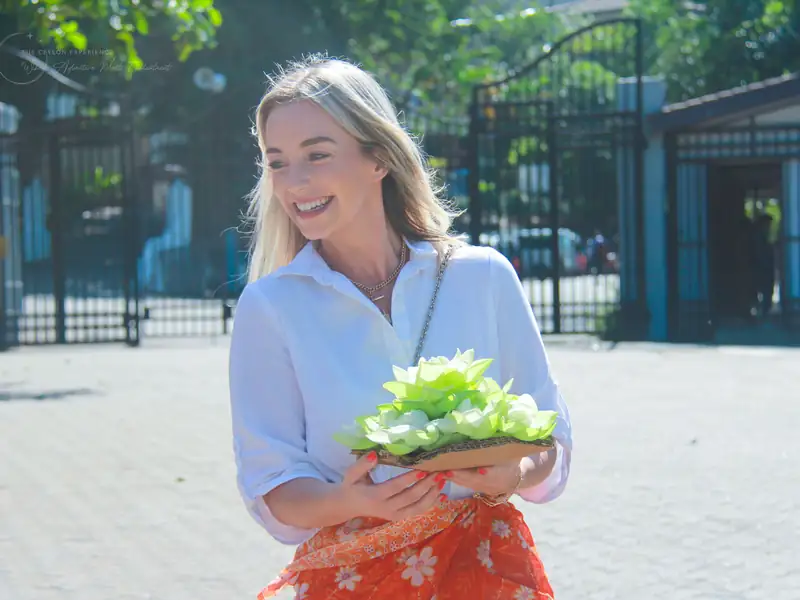 A guest carrying a flower offering to a temple